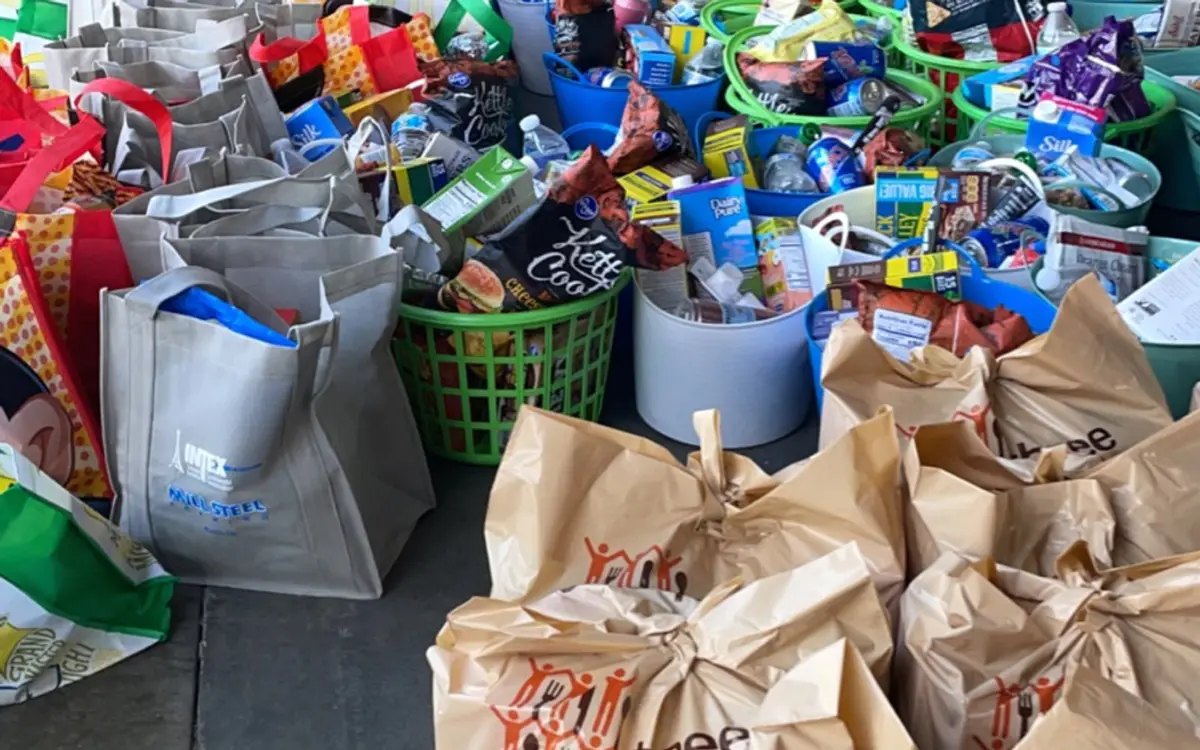 Rows of packed grocery bags and baskets ready for distribution to families